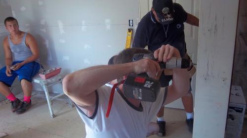 Screwing in the wallboard.