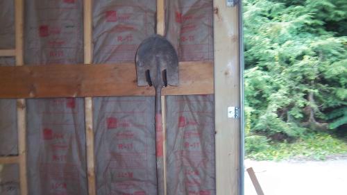 The rack holds a shovel at least