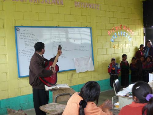 Upper Grade teacher leading singing with his class