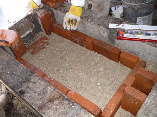Laying the first of the fire bricks